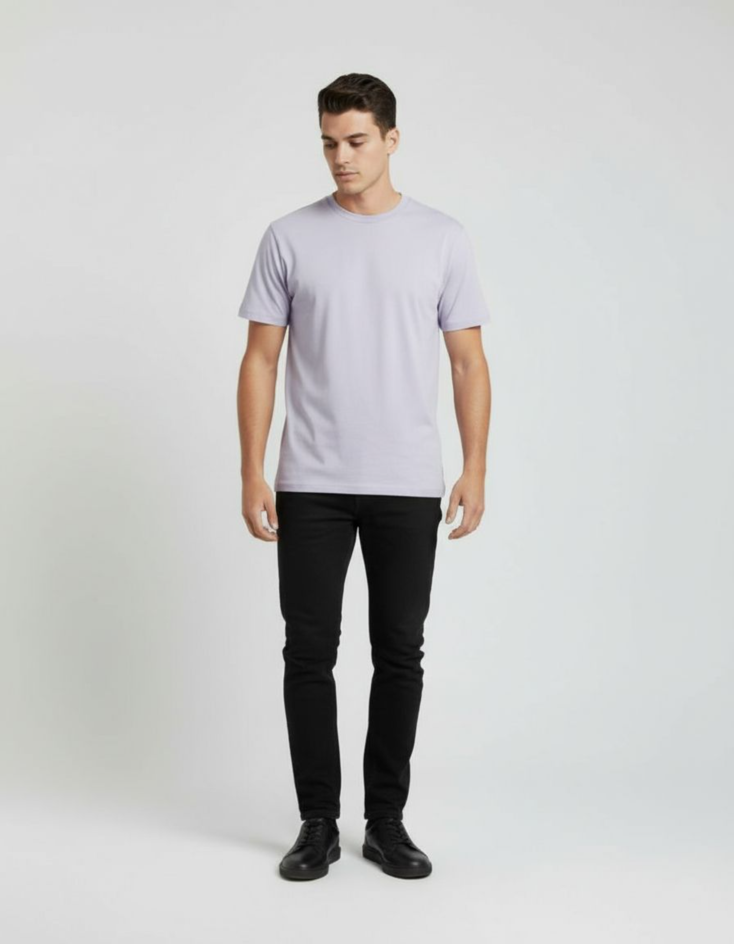 Man wearing a lavender t-shirt and black pants on a white background