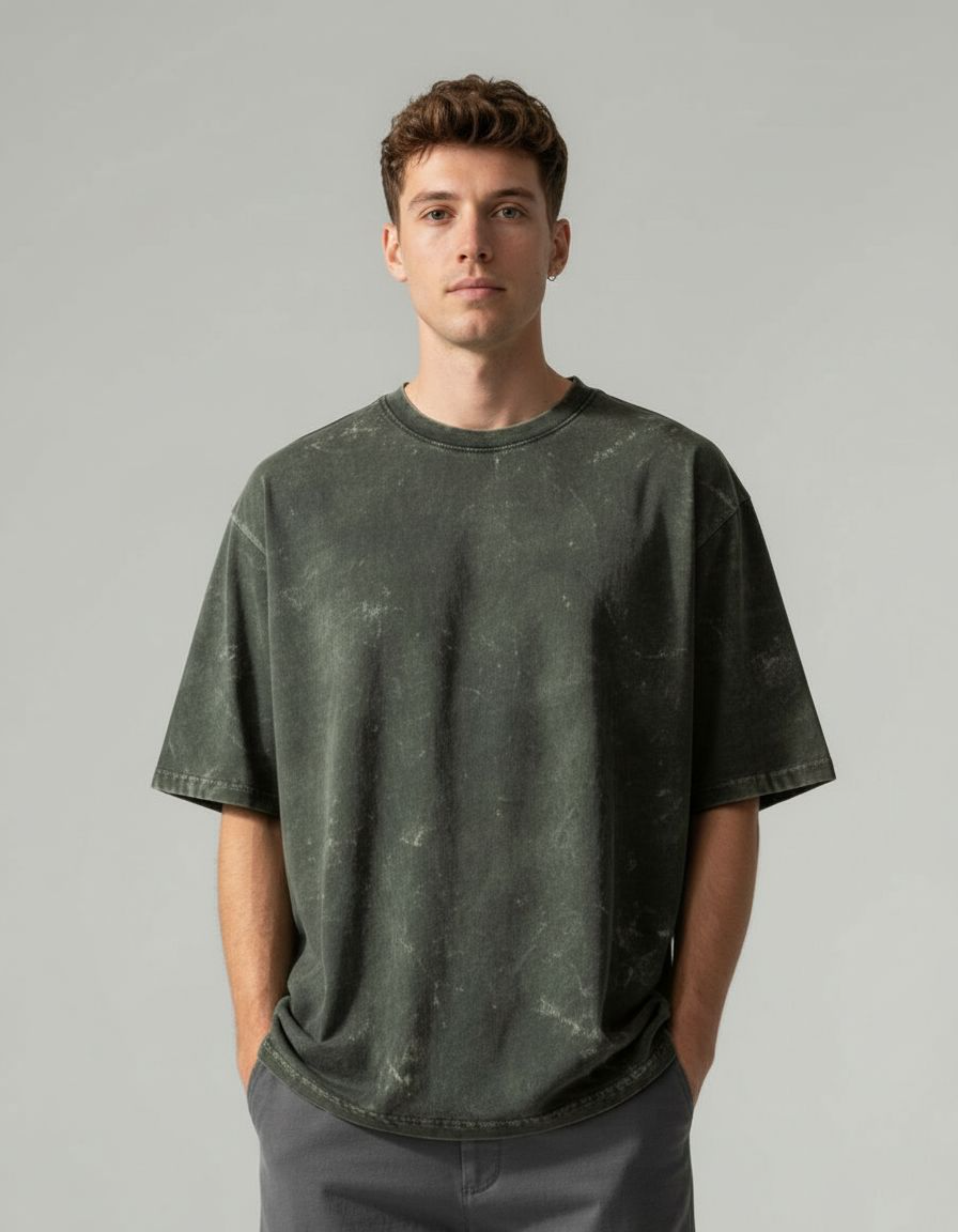 Man wearing an olive green acid washed t-shirt against a plain background