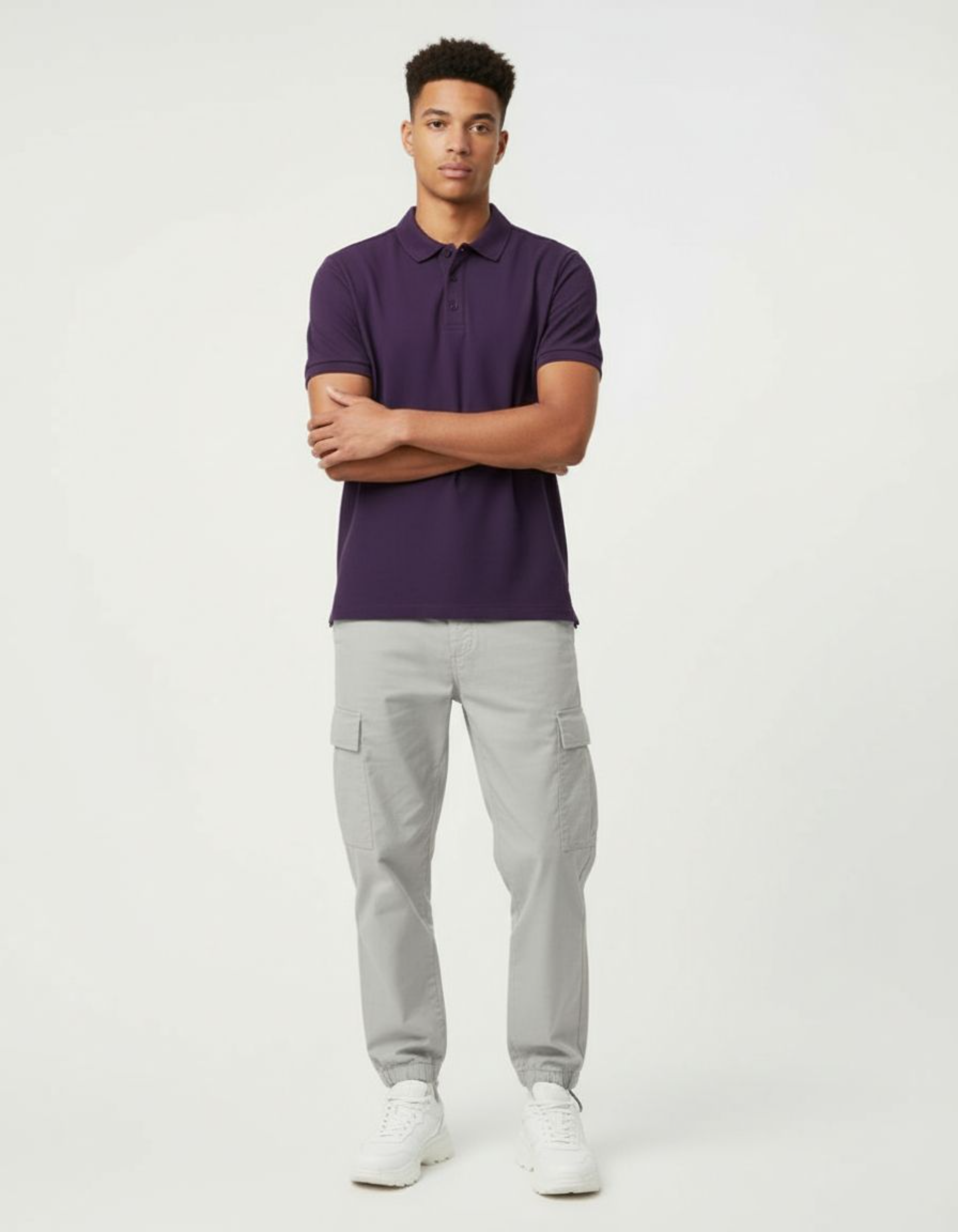 Man wearing a purple polo shirt and gray cargo pants on a white background