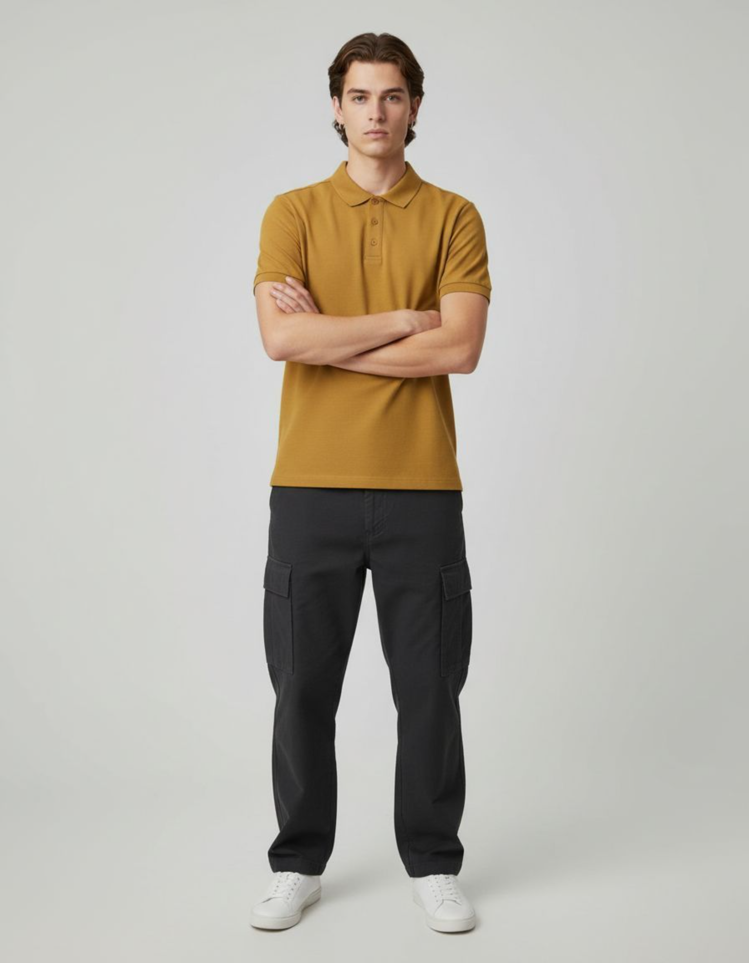 Man wearing a mustard yellow polo shirt and black cargo pants on a plain background