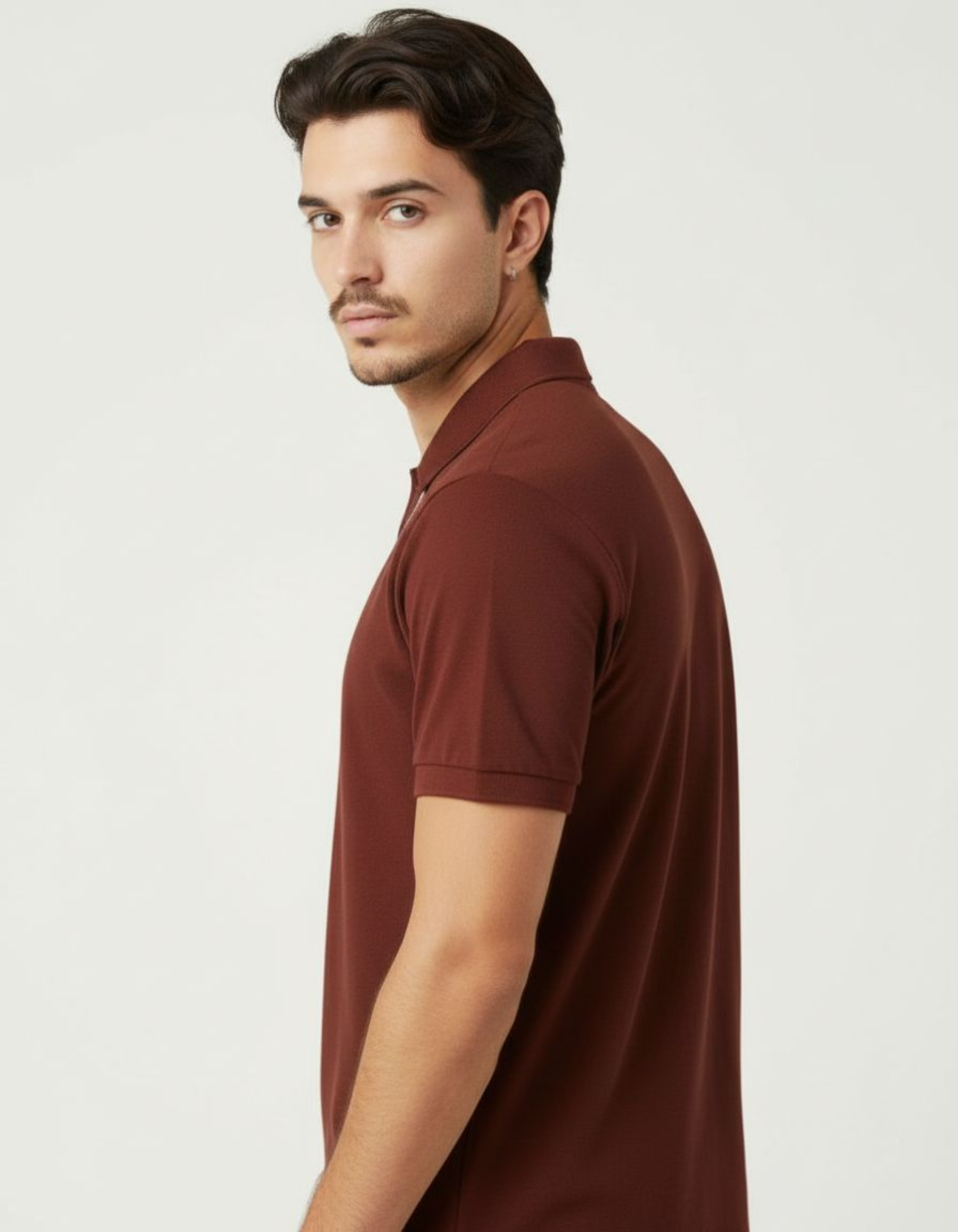 Man wearing a brick red polo shirt against a light gray background